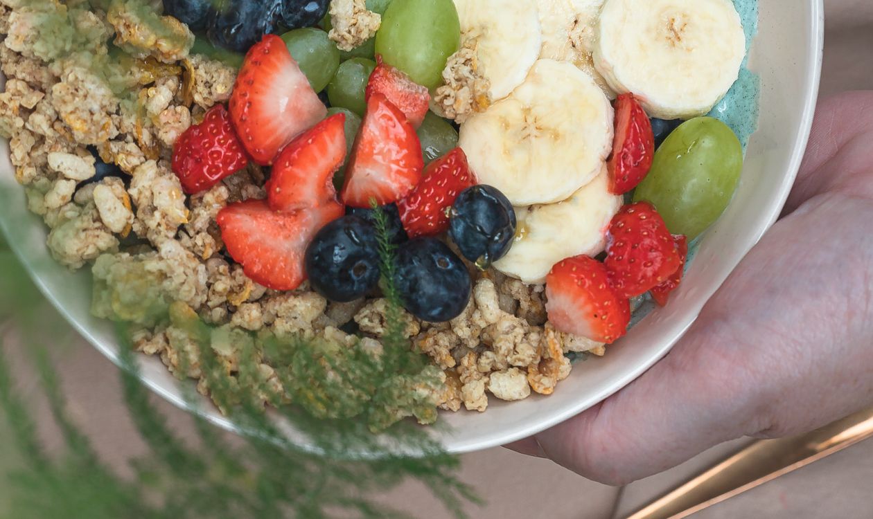 A colorful healthy breakfast bowl with mixed fruits and granola.